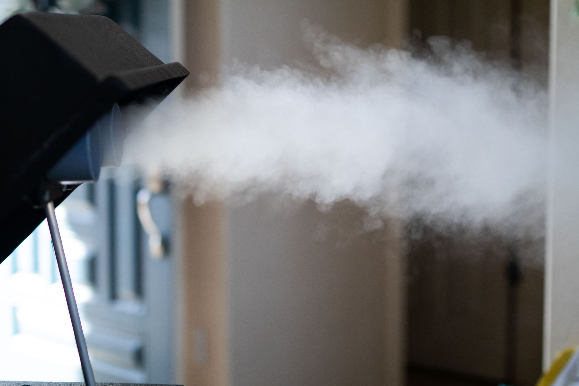 A SaniPure vaporizer releasing a cloud of dry vapor into a room